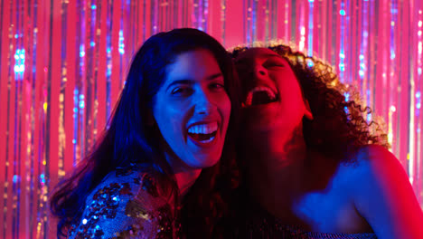 Portrait-Of-Two-Women-Friends-Having-Fun-Dancing-In-Nightclub-Bar-Or-Disco-With-Sparkling-Lights-2
